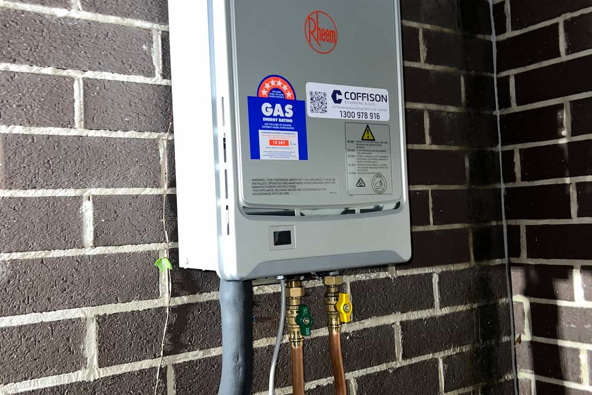 Wall-mounted Rheem gas hot water system professionally installed by Coffison Plumbing at a residential property.