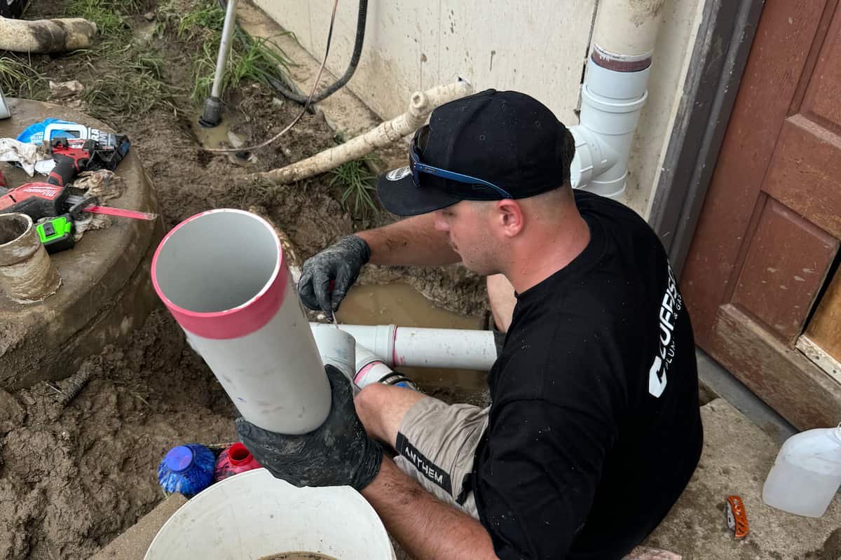 Coffison Plumbing technician replacing a blocked external drain pipe at a residential property in Brisbane.