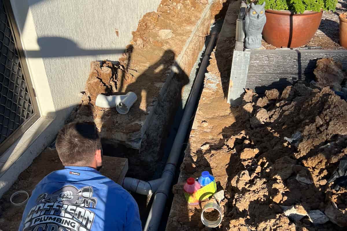 Blocked drain pipe being replaced by a Coffison Plumbing technician on-site in Brisbane.