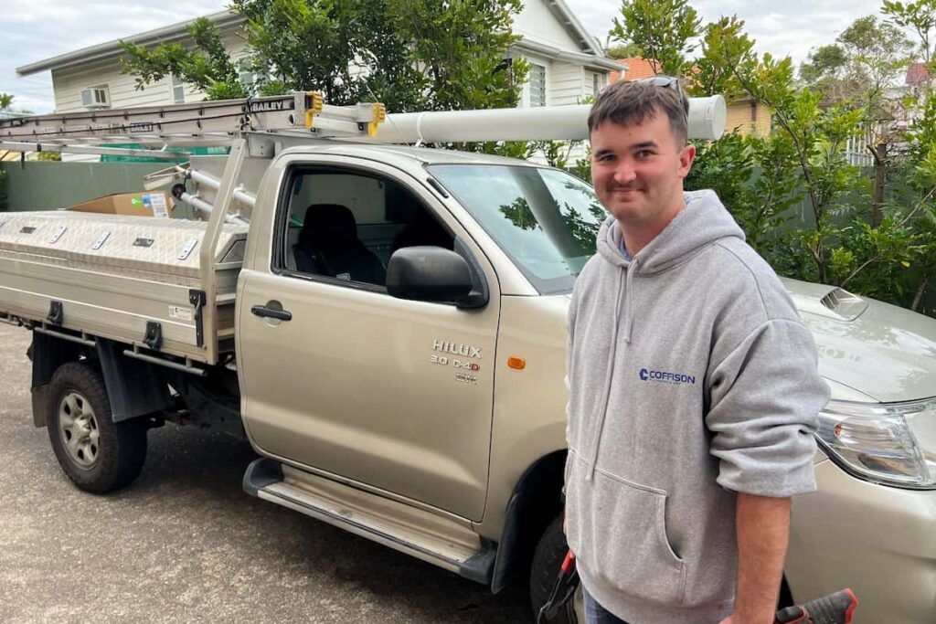Coffison Plumbing emergency plumber in Brisbane standing next to a work ute with tools, ready for an urgent callout.