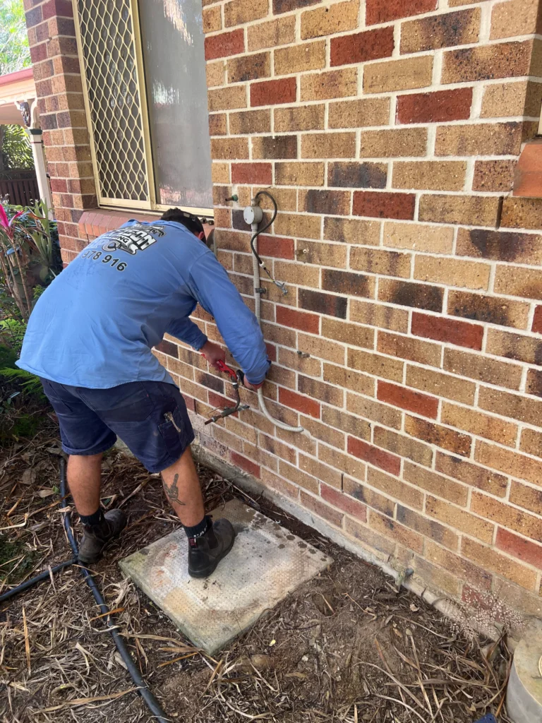 plumbing technician diagnosing bathroom pipe issue