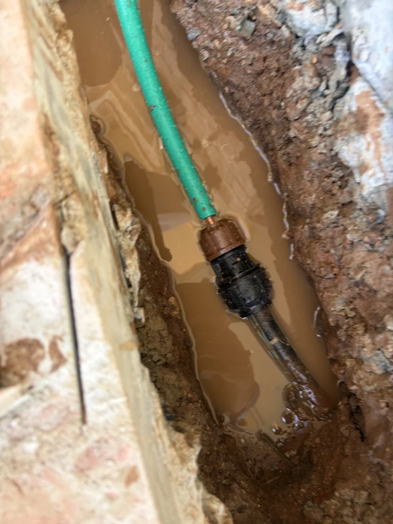 licensed plumber working on pipe installation in a home