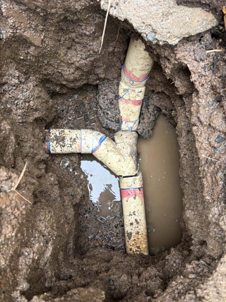 Exposed sewer junction beneath the concrete slab at Allan's Redcliffe property